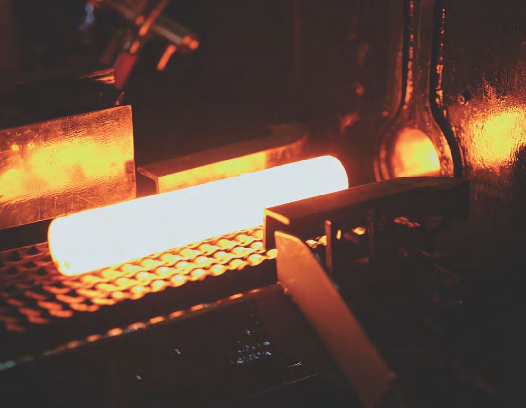 Red-hot billet on the conveyor of an induction heater