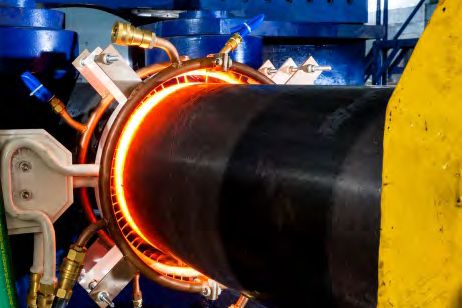 Steel pipe glowing inside an induction ring coil